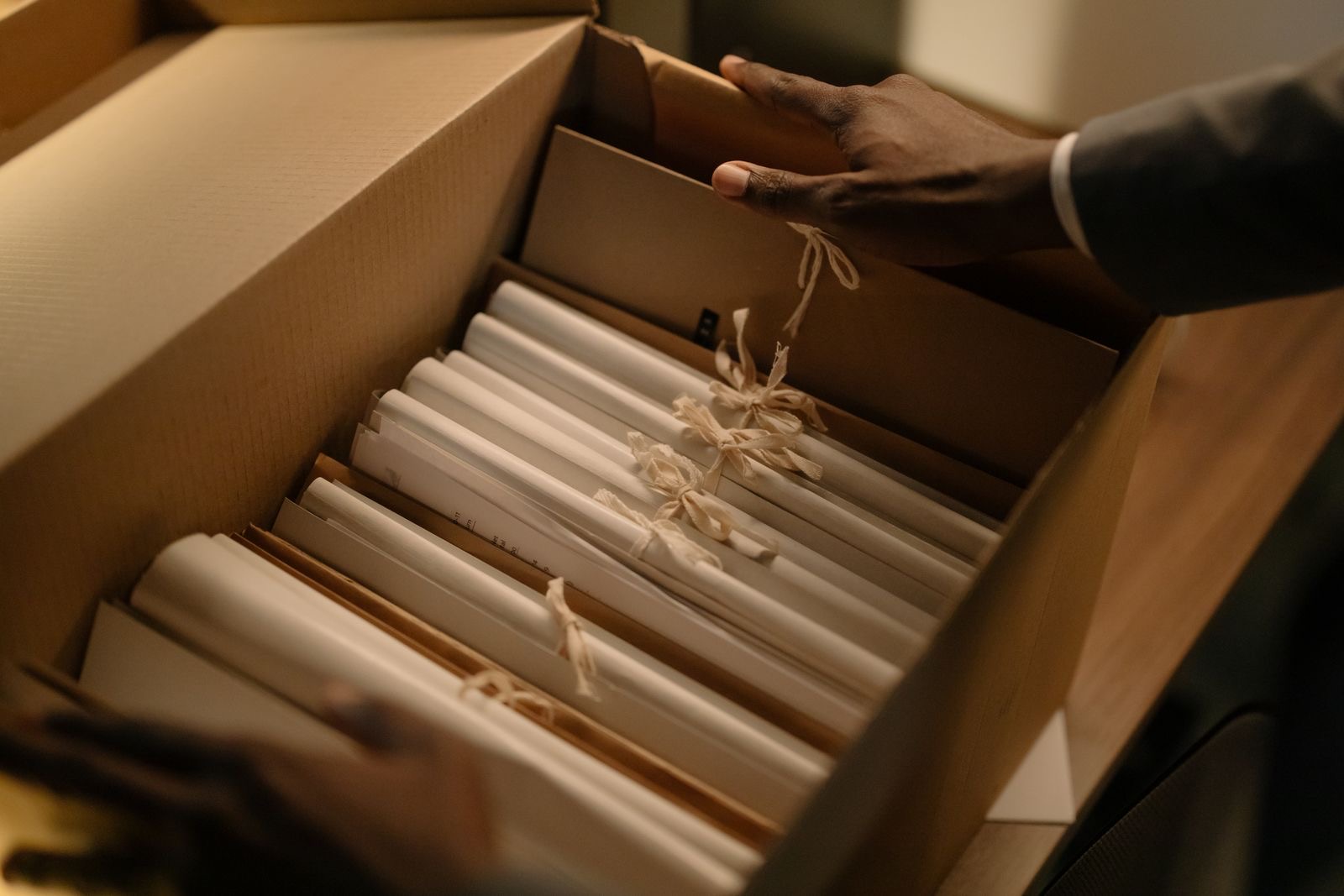 Hands sorting a folder of corporate documents on a desk