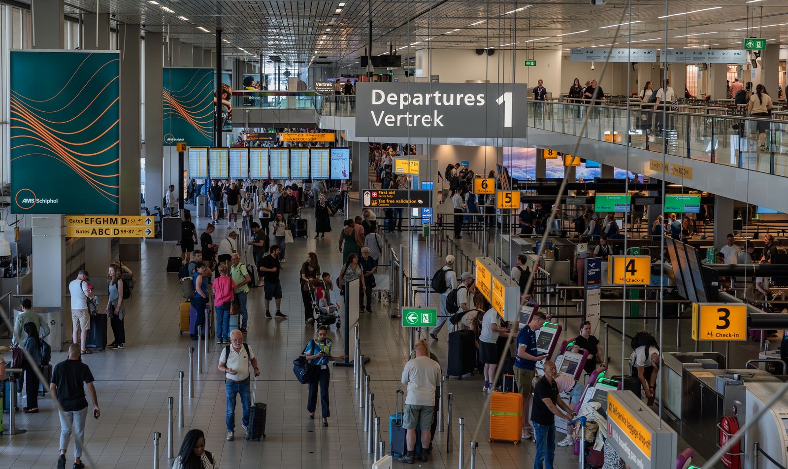 Travellers with luggage in an airport departures hall