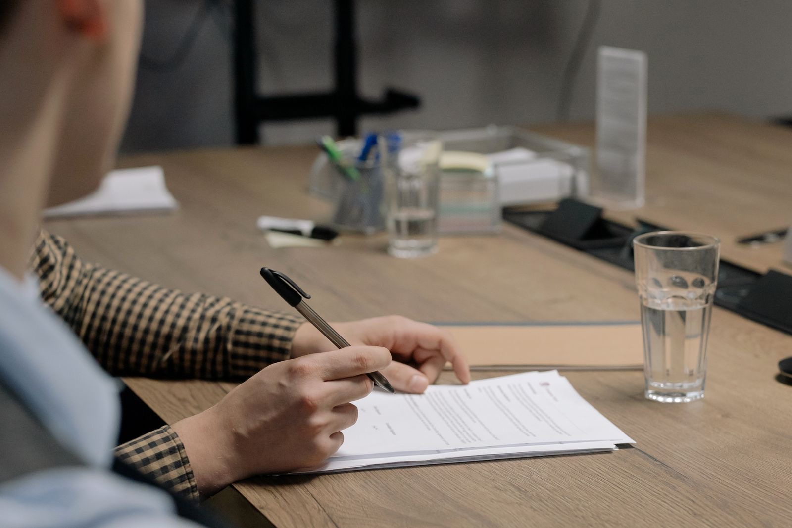 A folder of signed documents and a pen on a desk