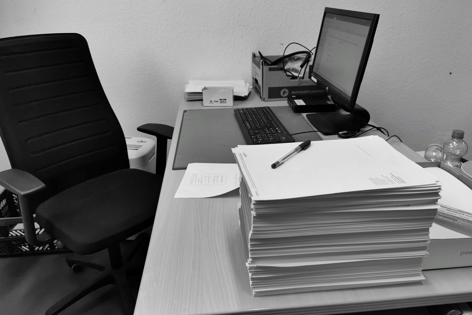 Signed corporate documents and a binder on an office desk in Brussels