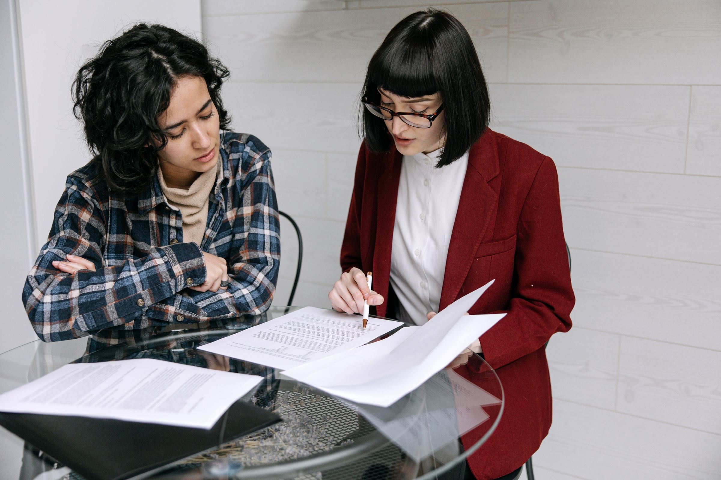 Two business partners reviewing a contract at an office table