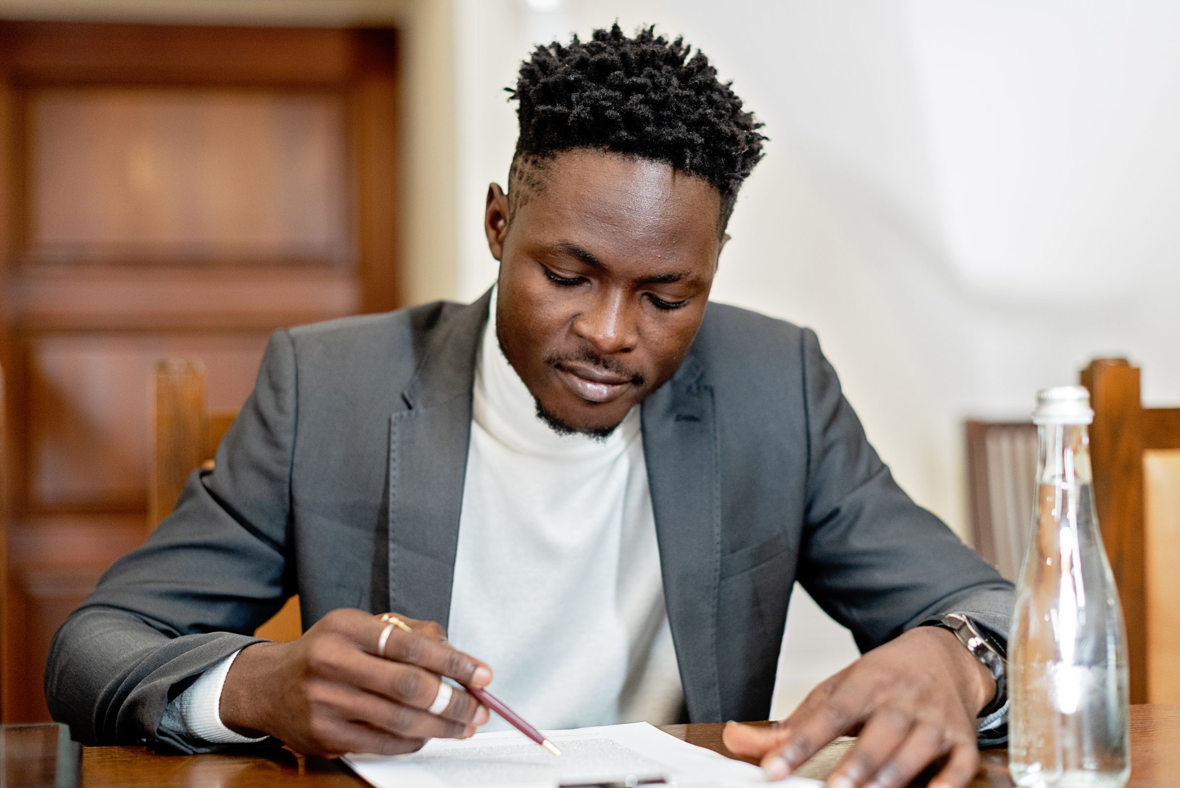 A notary and two clients signing company documents at a desk
