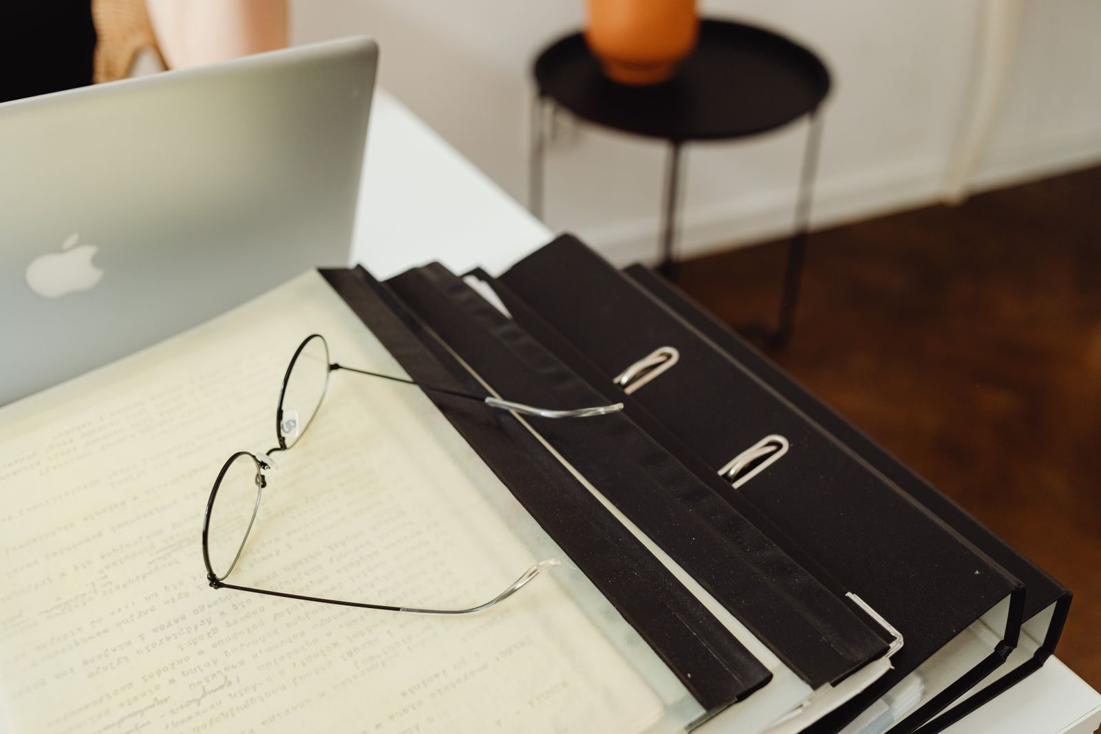 A desk with a laptop and a closed folder of employment paperwork