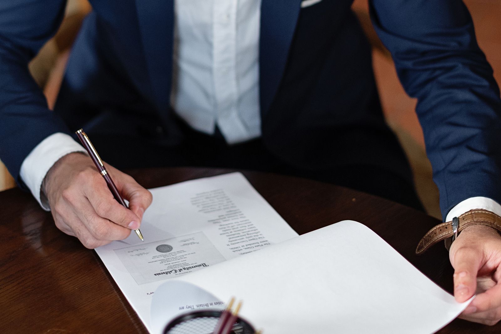 Hands signing a document at a desk