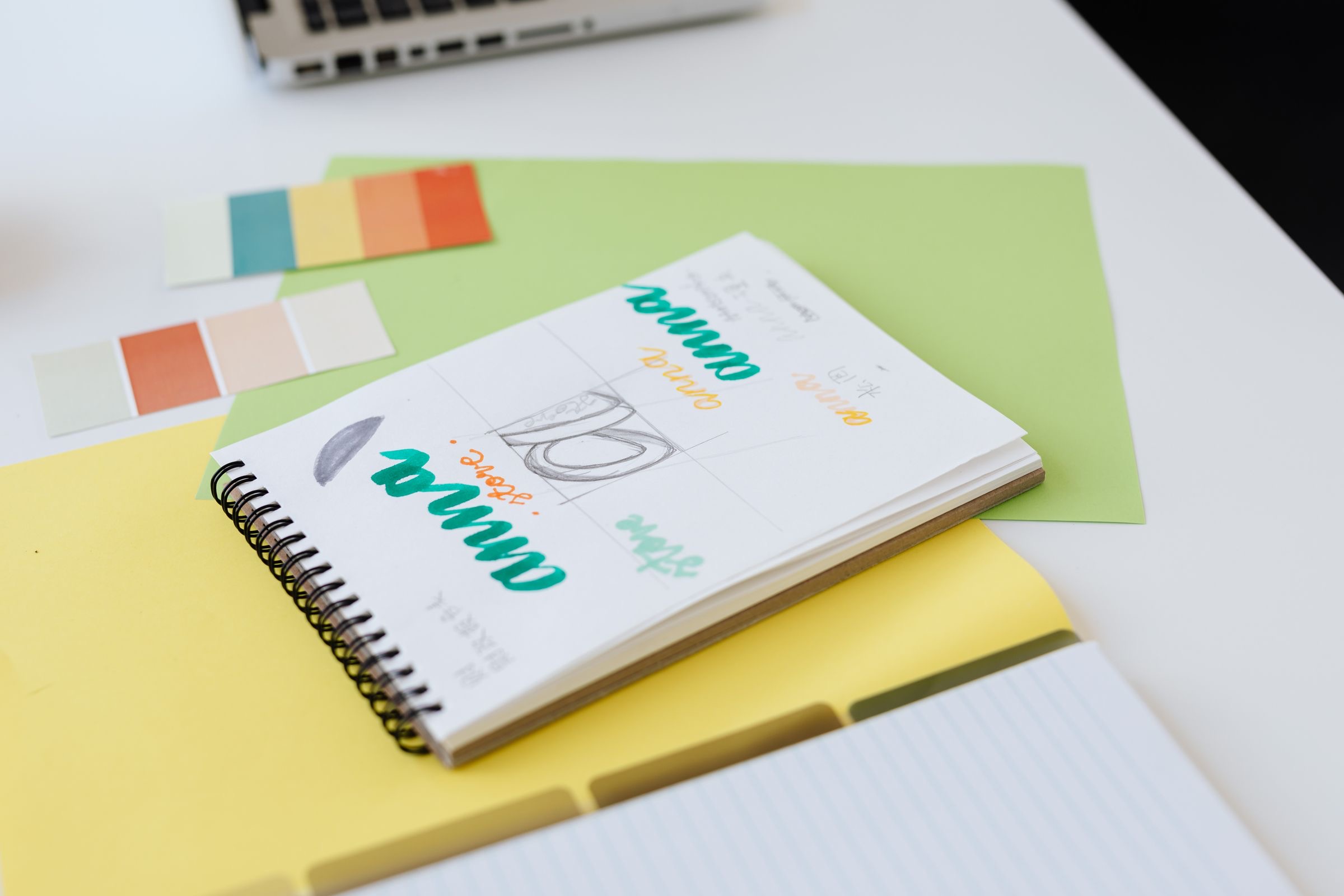 A designer sketching a brand mark on paper at a desk