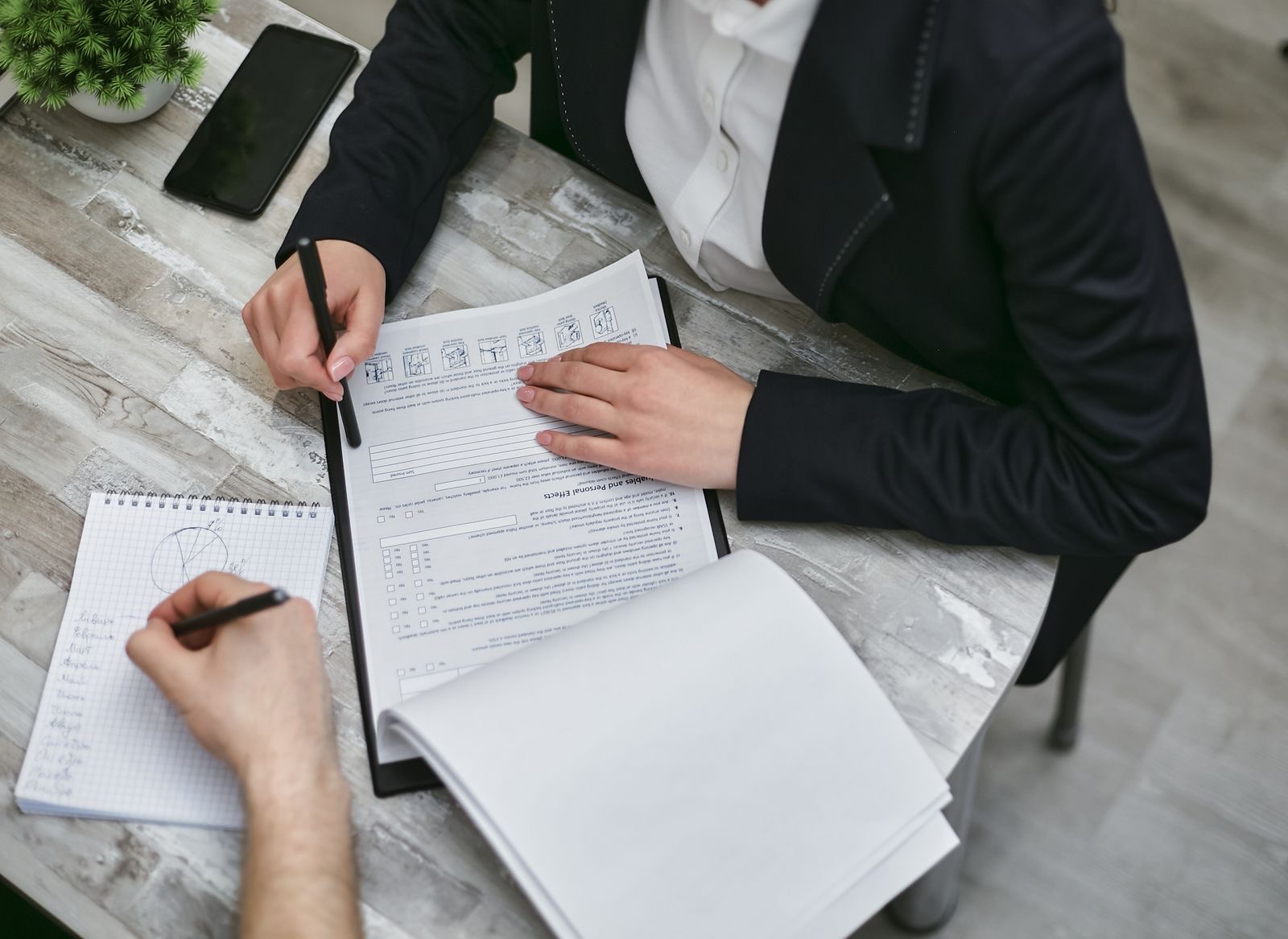 Hands arranging a folder of documents on a desk