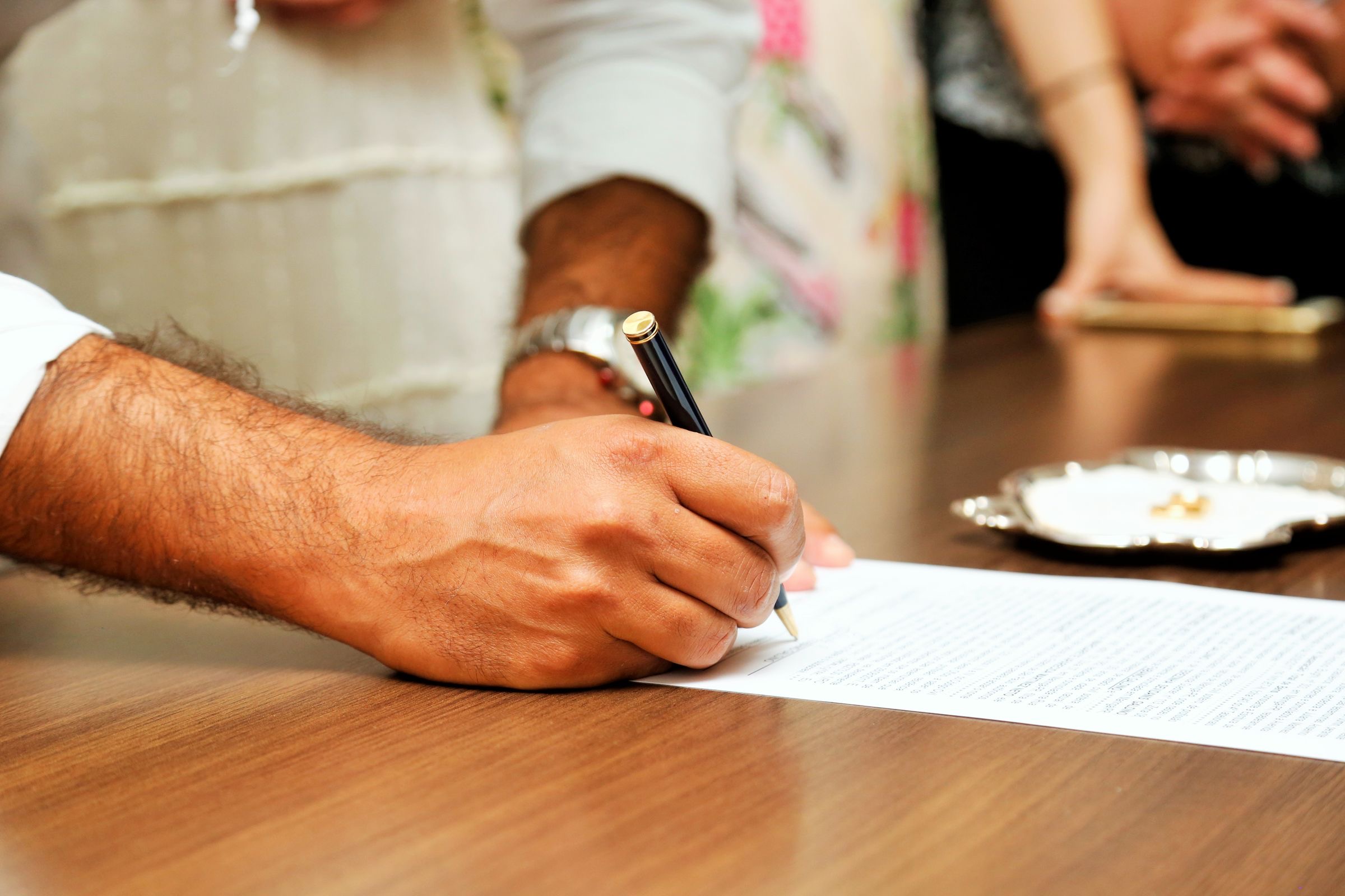 A notary and two clients reviewing documents at a desk before a signing